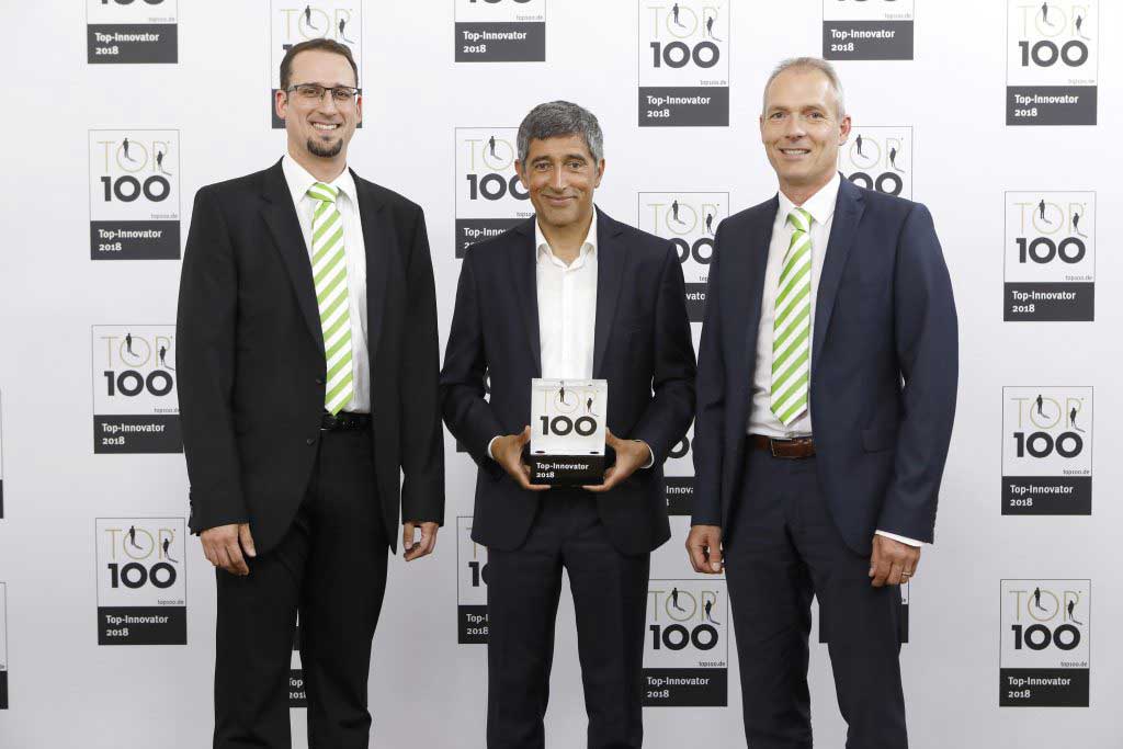 Drei Männer im Anzug; Preisannahme TOP 100 Innovator 2018