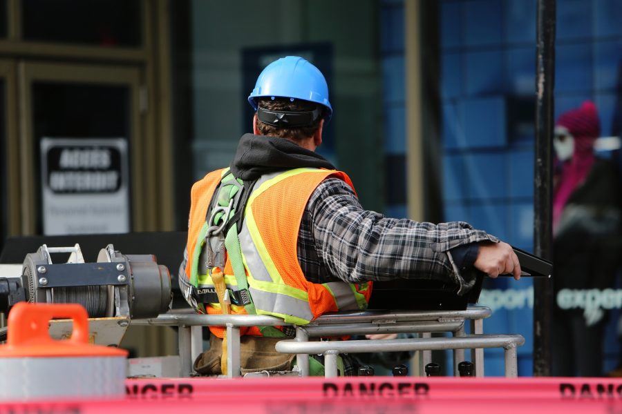 Bauarbeiter in Warnschutzweste und blauem Schutzhelm