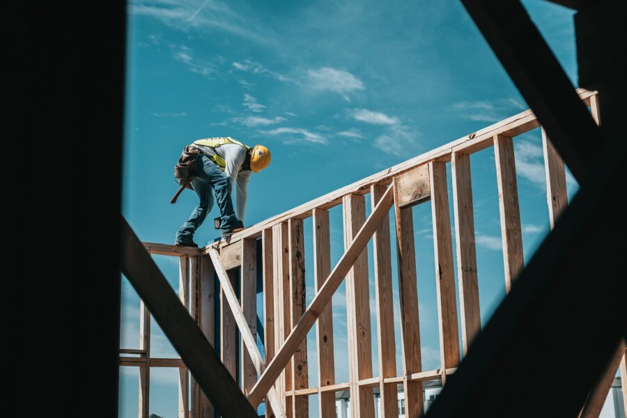 Arbeiter auf Holzgerüst eines Hauses