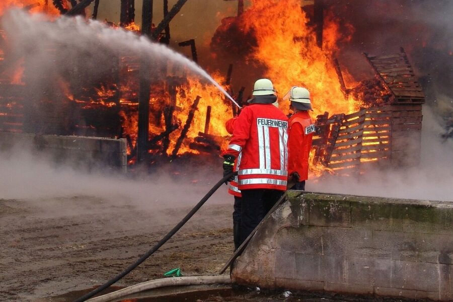 Feuerwehrleute, die ein brennendes Lagerhaus löschen